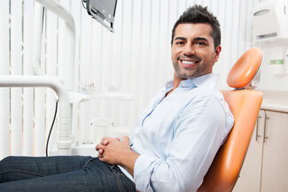 man sitting in dental office chair smiling, dental implants Scottsdale, AZ
